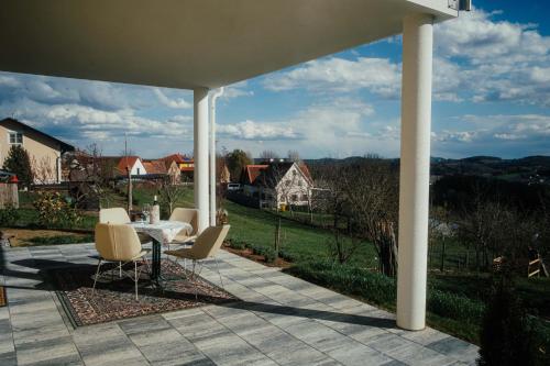 patio con mesa, sillas y vistas en Gästehaus Jeindl, en Hartmannsdorf