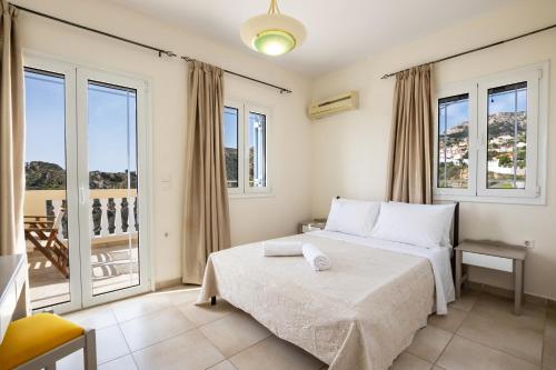 a bedroom with a bed and a balcony at Karpathos View Villa in Karpathos