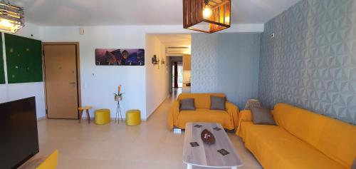 a living room with a yellow couch and a table at Δροσιά in Nafplio