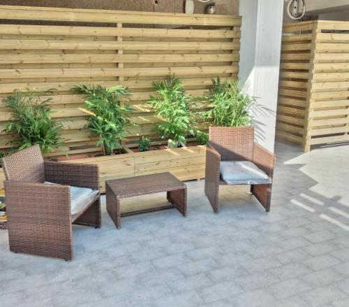 patio z 2 krzesłami, stołem i ogrodzeniem w obiekcie HomeFamily w mieście Lido di Ostia