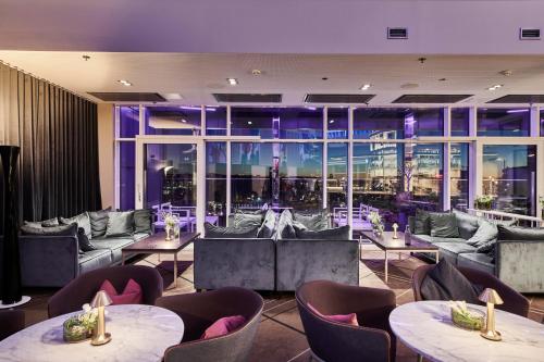 a restaurant with tables and chairs and a large window at Gothia Towers & Upper House in Gothenburg