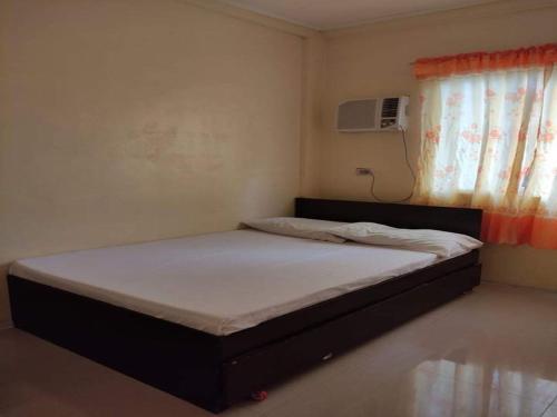 a small bedroom with a bed with a window at Dannykaela Transient House in Vigan
