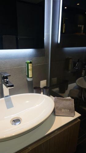a white sink in a bathroom with a mirror at Maurers Schlierseetraum 6, Studio 455 mit 42 qm neu renoviert, Erdgeschoss mit eingezäunter Terrasse in ruhiger Lage am Kirchbichlweg 8 in Schliersee
