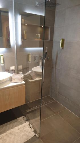 a bathroom with a glass shower and a sink at Maurers Schlierseetraum 6, Studio 455 mit 42 qm neu renoviert, Erdgeschoss mit eingezäunter Terrasse in ruhiger Lage am Kirchbichlweg 8 in Schliersee