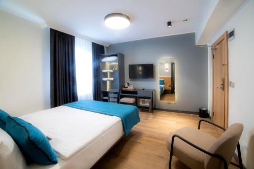 a bedroom with a bed and a desk and a television at Barin Hotel in Istanbul