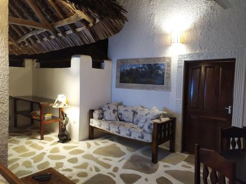 瓦塔穆Twiga House Resort [ Piscina ☆☆☆☆☆ ] Pearl Beach的客厅里有一张沙发和一张桌子。