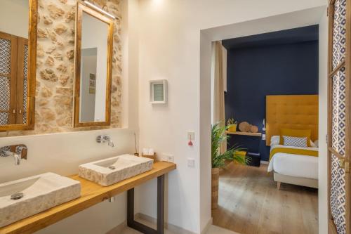 a bathroom with a sink and a bedroom at Can Vidal Boutique Rooms in Inca