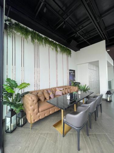 a room with a couch and a table and chairs at Harmony Phnom Penh Hotel in Phnom Penh