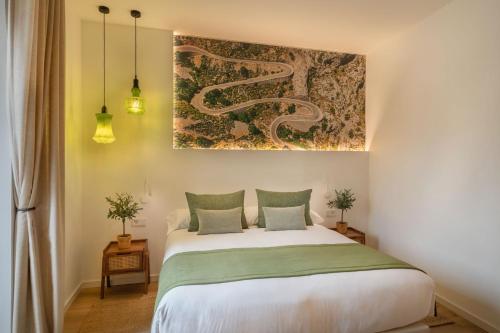 a bedroom with a bed and a painting on the wall at Can Vidal Boutique Rooms in Inca
