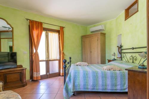 1 dormitorio con 1 cama, TV y ventana en Flores, en Roccastrada