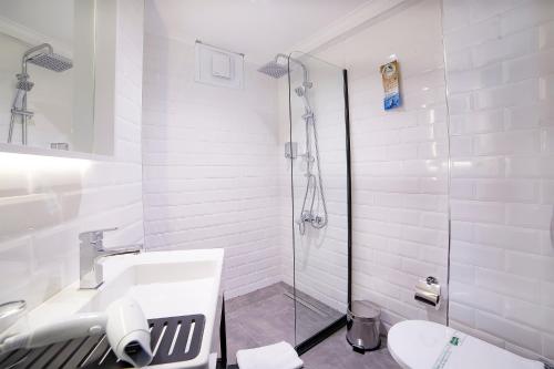 baño blanco con ducha y lavamanos en Barin Hotel, en Estambul