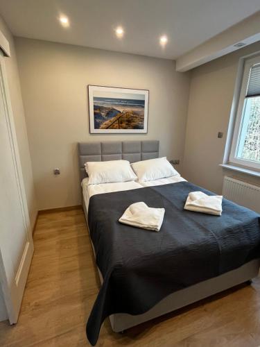 a bedroom with a bed with two towels on it at Domek przy promenadzie in Kołobrzeg