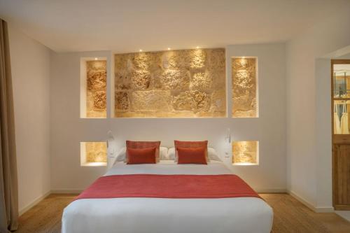 a bedroom with a large white bed with two orange pillows at Can Vidal Boutique Rooms in Inca