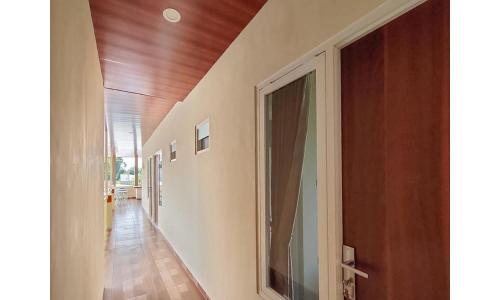 a hallway of a house with a door and wooden floors at RedDoorz near BNS Batu in Tlekung