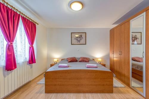a bedroom with a bed with pink curtains at Apartment Flores in Stari Pazin