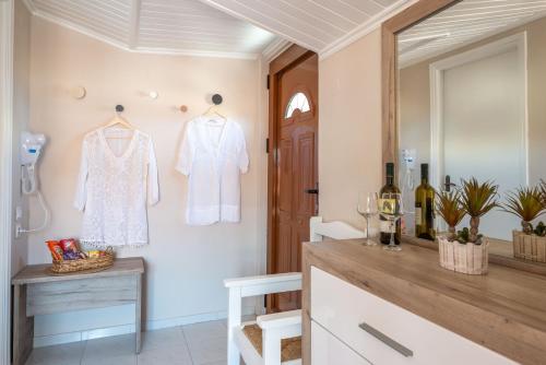 a dressing room with a white shirt hanging on a wall at Esperides Studios in Syvota