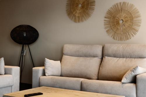 a living room with a couch and two fans on the wall at Apartamentos Mirador in Benidorm