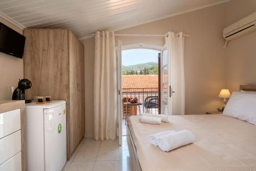 a room with a bed and a kitchen with a balcony at Esperides Studios-Seaside Stay with View in Syvota in Syvota