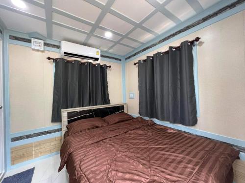 a bedroom with a large bed with black curtains at ภูผาม่านห่มดาวแคมป์ in Ban Huai Hai