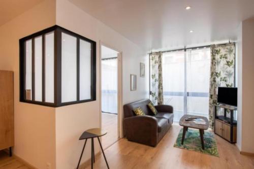 un salon avec un canapé et une télévision dans l'établissement Charmant Dieppois, 2 chambres, centre ville, à Dieppe