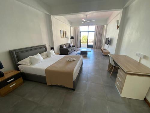 um quarto de hotel com uma cama e uma sala de estar em Dragon Nest Apartments em Port Louis