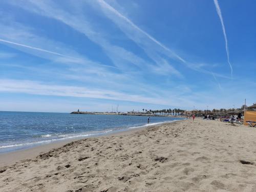 a beach with people walking on the sand and the ocean at Apartamento Pepita Alay in Benalmádena
