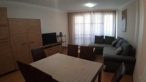 a living room with a couch and a table with chairs at Apartament Sarafovo in Burgas