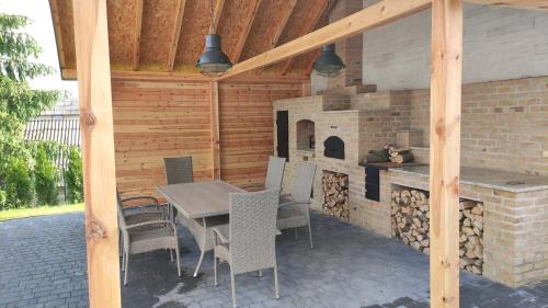 eine Terrasse mit einem Tisch, Stühlen und einem Kamin in der Unterkunft Eco Pueblo in Wola Gardzienicka