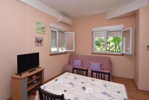 a living room with a table and a couch and a television at Apartment Meri- near the Zadar main bus station in Zadar