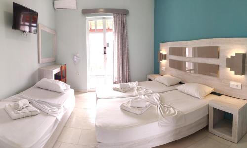 a bedroom with two beds and a window at Giannis Studios in Alykes