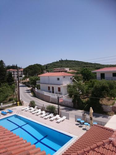 
a large white swimming pool in front of a house at Giannis Studios in Alykes
