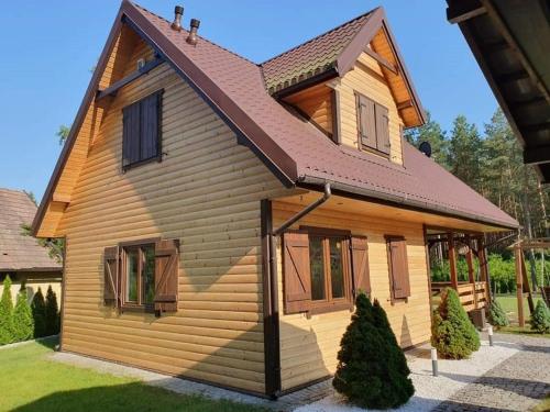 a wooden house with a gambrel roof at Dom letniskowy Zielonowo in Zieleniak