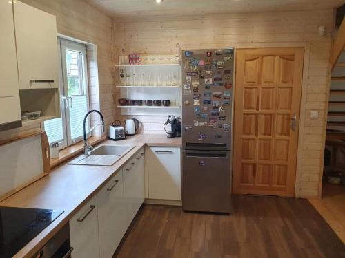 a kitchen with a refrigerator and a sink at Dom letniskowy Zielonowo in Zieleniak