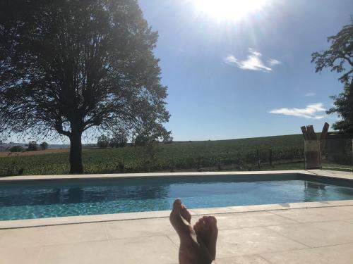 a person laying down next to a swimming pool at Best view, pool and spa on the Champagne vineyard in Saint-Thierry