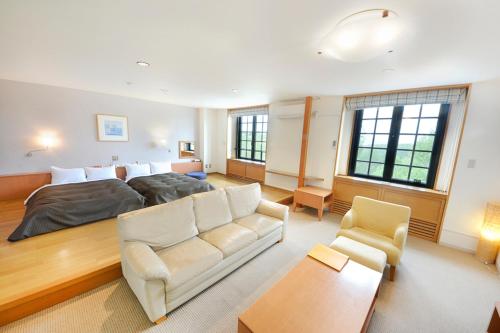 a living room with a bed and a couch at Tabist Hotel Colosseum Inn Tateshina in Tateshina