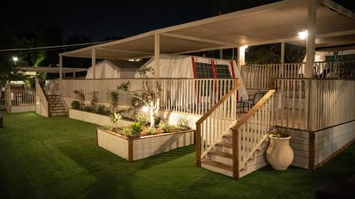 a house with a staircase and some plants in a yard at The Riders' Experience - Glamping and Attractions Park- Full Board in Bet Oren
