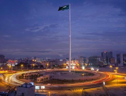 a flag on a pole in a city at night at Aster Hotel in Jeddah