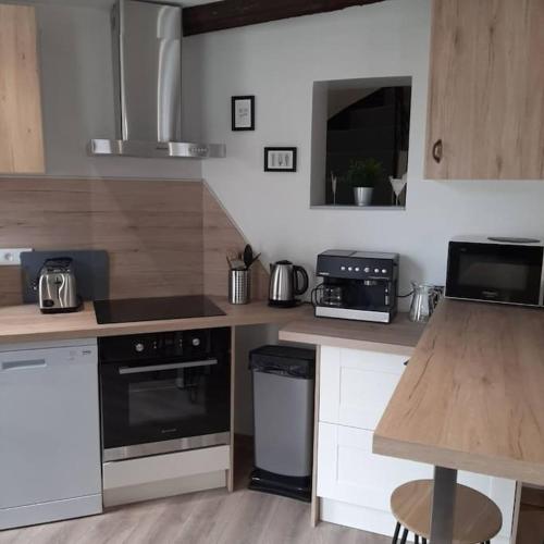 une cuisine avec des armoires blanches et un comptoir dans l'établissement Maison de ville, à Vic-le-Comte