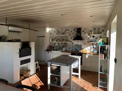 una cocina con armarios blancos y una mesa. en Askebo Brygghus, en Gislaved