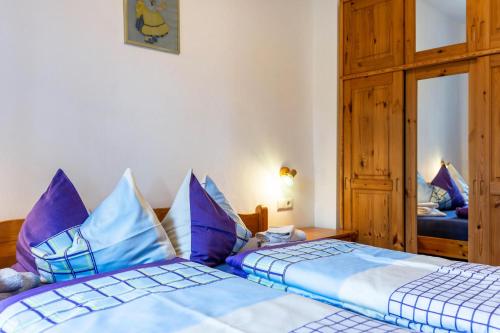 a bedroom with two beds with blue and white pillows at Sallrain Hof Apartment 1 in Collalbo