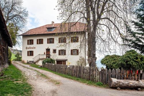 an old white house with a wooden fence at Sallrain Hof Apartment 1 in Collalbo