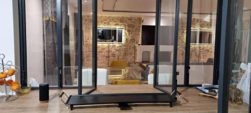 une salle de sport avec des murs en verre dans l'établissement La Villa Jacuzzi et Cinéma 