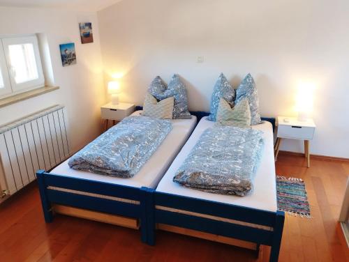 two twin beds in a room with two lamps at Apartment SENA in Vodnjan