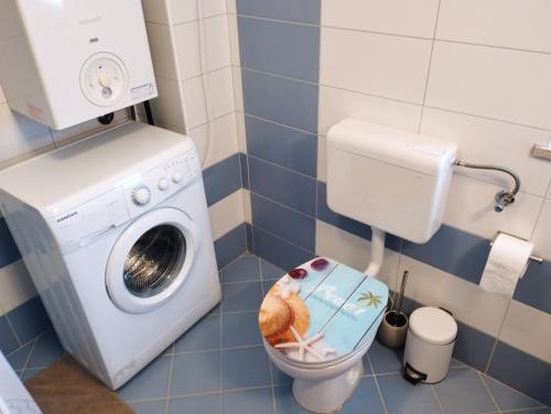 a bathroom with a washing machine and a toilet at Apartment SENA in Vodnjan