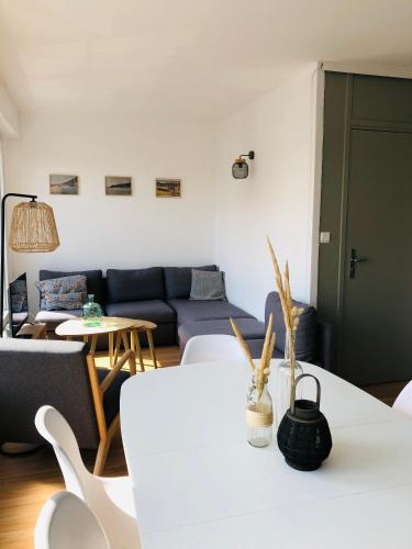 a living room with a couch and a table at Appartement C 2 chambres très lumineux in Neufchâtel-Hardelot