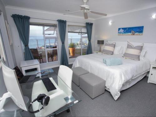a bedroom with a bed and a desk with a computer at Go2Boa Luxury Apartment in Mossel Bay