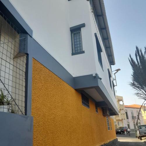 a yellow and white building with a window on it at A Casa da Mizi in Praia