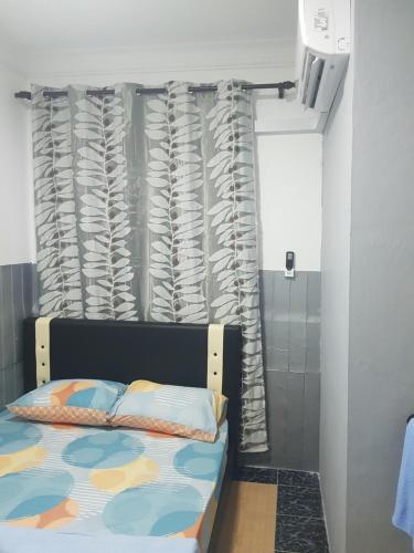um quarto com uma cama e uma cortina em Orchid Roomstay em Labuan