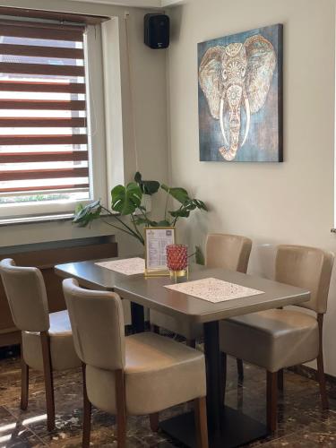 a dining room table and chairs with a picture on the wall at Hotel Post Sindelfingen in Sindelfingen