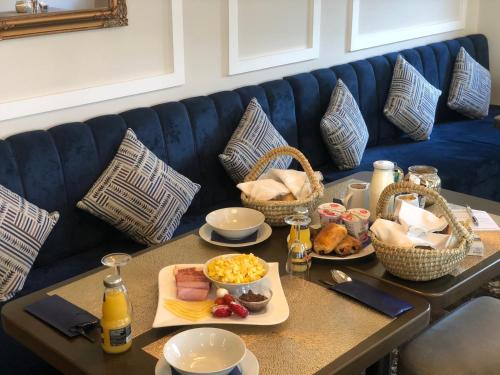 a table with plates of food on a blue couch at Hotel Post Sindelfingen in Sindelfingen